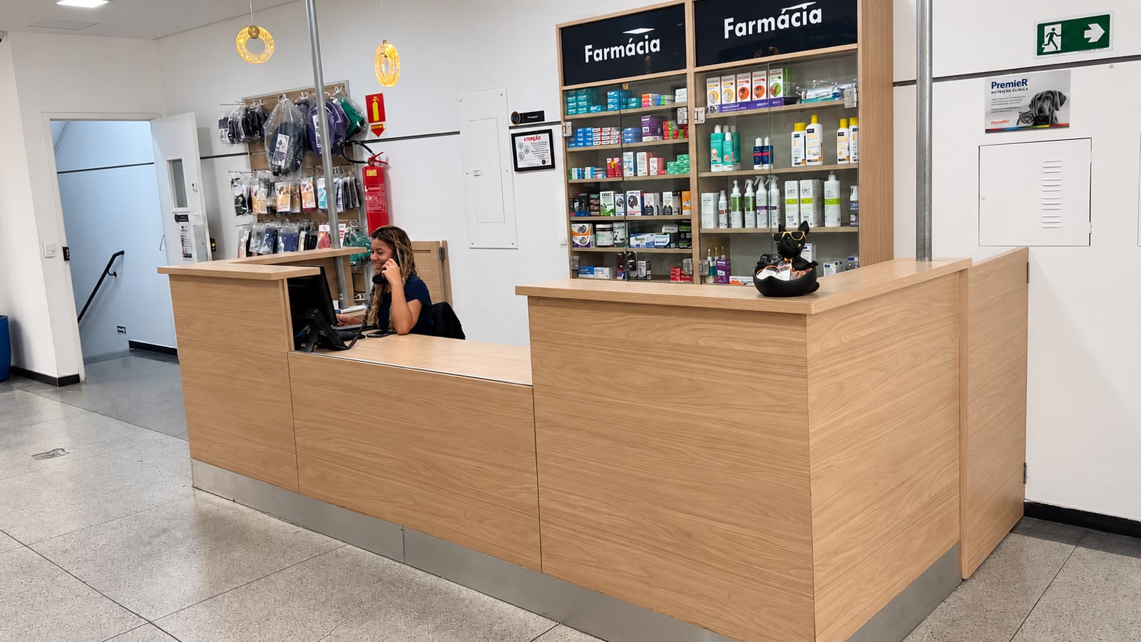 Recepção da Dog's Company com balcão de atendimento e prateleiras da farmácia ao fundo